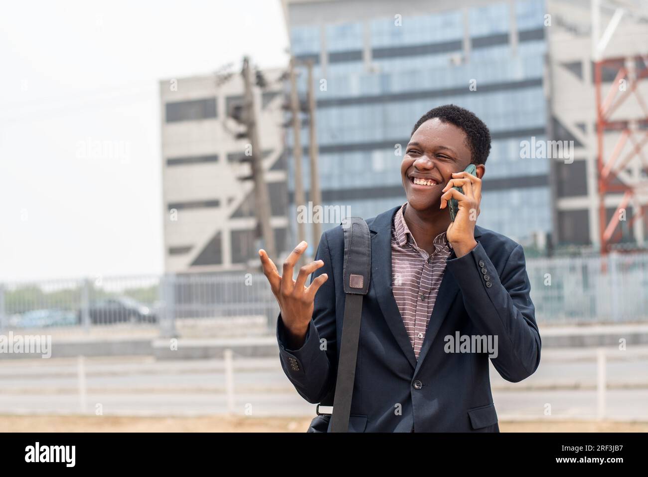 Ein junger afrikaner, der zur Arbeit geht und telefoniert Stockfoto