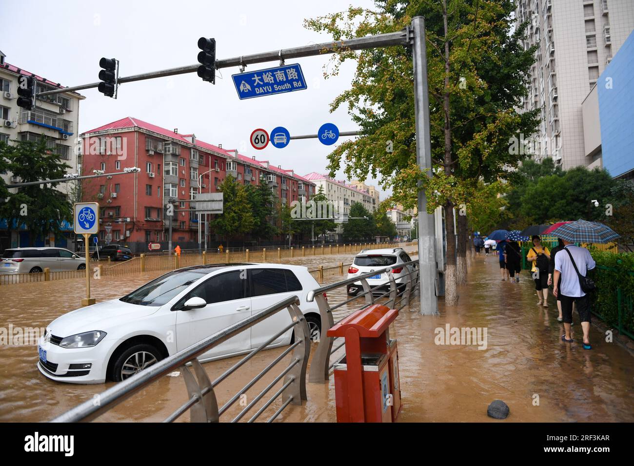 Peking, China. 31. Juli 2023. Passagiere gehen im Mentougou-Bezirk von Peking, Hauptstadt von China, am 31. Juli 2023 an Autos vorbei, die unter Wasser stehen. Bis 4 Uhr Am Montag hatte die chinesische Hauptstadt 40 Stunden ununterbrochenen Regen erlebt. Die Daten zeigen, dass es ab 8 Uhr ist Samstag bis 3 Uhr Montag betrug die durchschnittliche Niederschlagsmenge in Peking 193,4 mm, wobei die maximale Niederschlagsmenge an einem malerischen Ort im Bezirk Mentougou 580 mm überstieg. Kredit: Ju Huanzong/Xinhua/Alamy Live News Stockfoto
