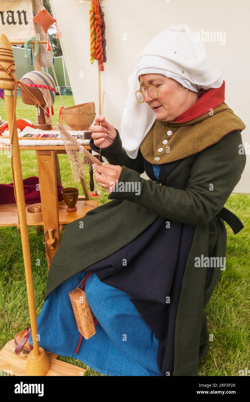 England, Kent, Maidstone, Leeds, Leeds Castle, Mittelalterliches Festival, Portrait of Woman in Medieval Costume Weaving Seide Stockfoto