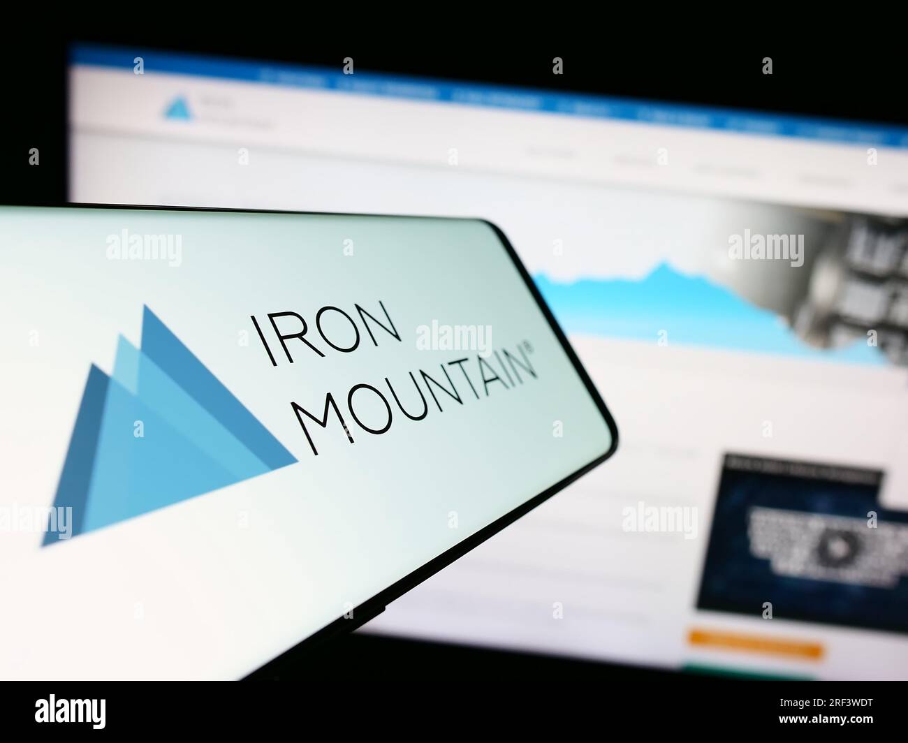 Handy mit Logo der amerikanischen Firma Iron Mountain Inc. Auf dem Bildschirm vor der Business-Website. Konzentrieren Sie sich auf die Mitte des Telefondisplays. Stockfoto