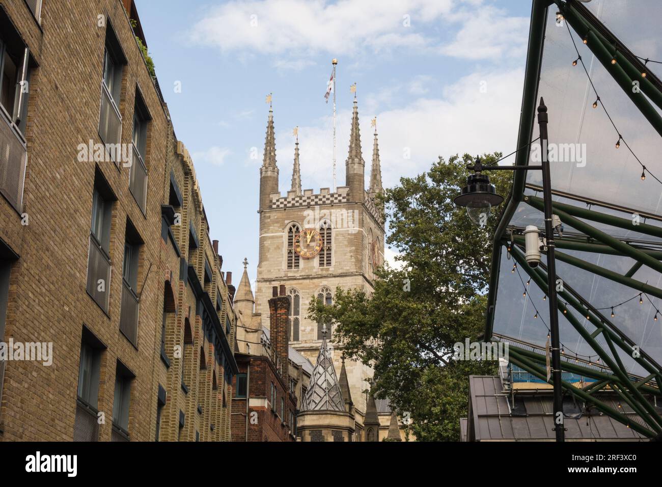 Ein Paar mittleren Alters, das eine hübsche Seitenstraße entlang läuft, die zur Southwark Cathedral in London, Großbritannien, führt Stockfoto