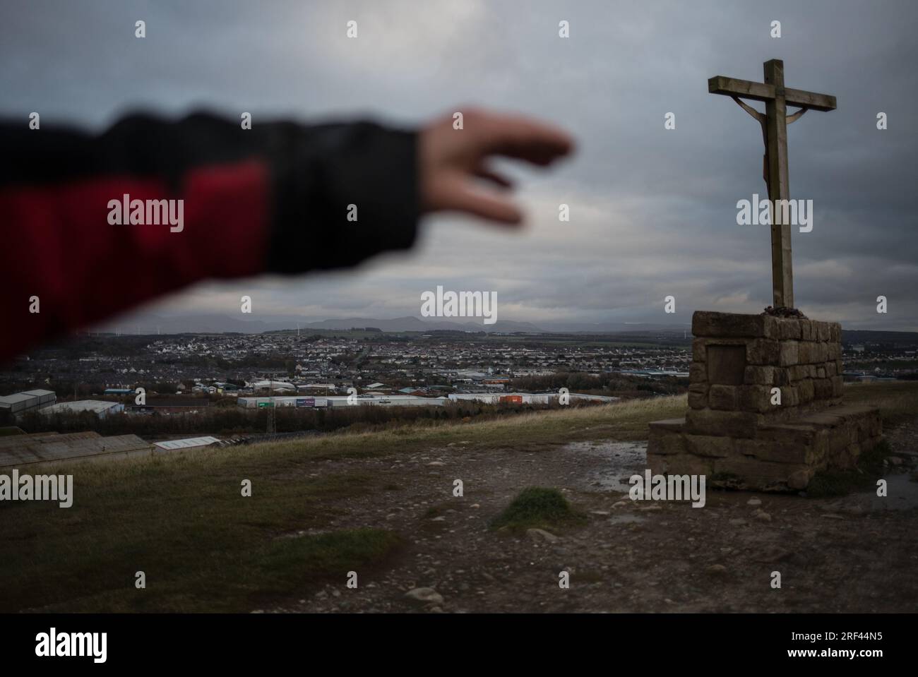 Bob Richardson (77 Jahre alt, ehemaliger Stahlarbeiter), und Blick auf die Stadt mit Kruzifix auf dem Sockel auf den Klippen an der Küste, in Workington, England, am 5. November 2019. Stockfoto