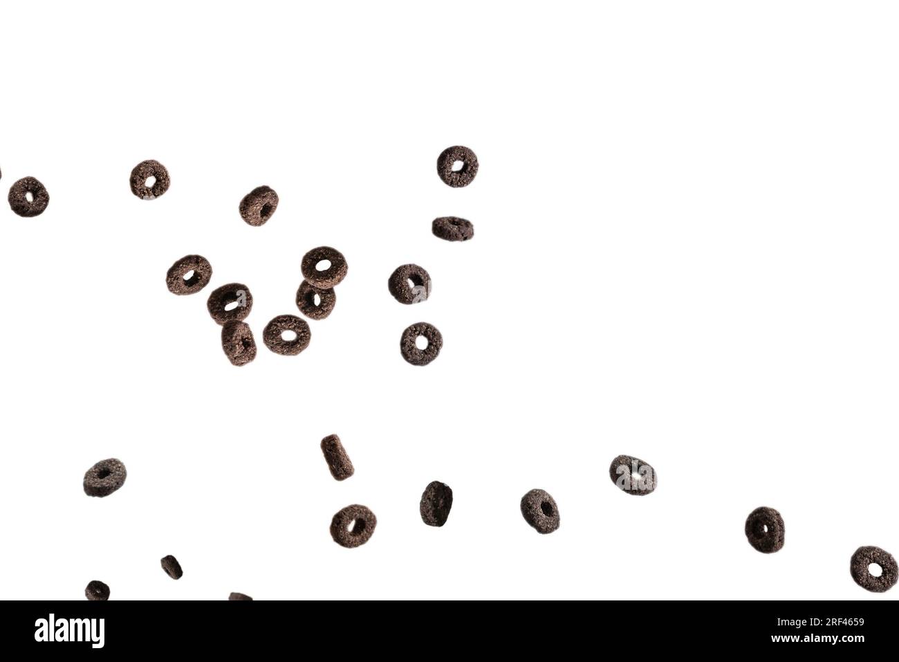 Schokoladen-Ringe Müsli verschüttet in eine Schüssel. Frühstück. Isoliert auf weißem Hintergrund. Stockfoto