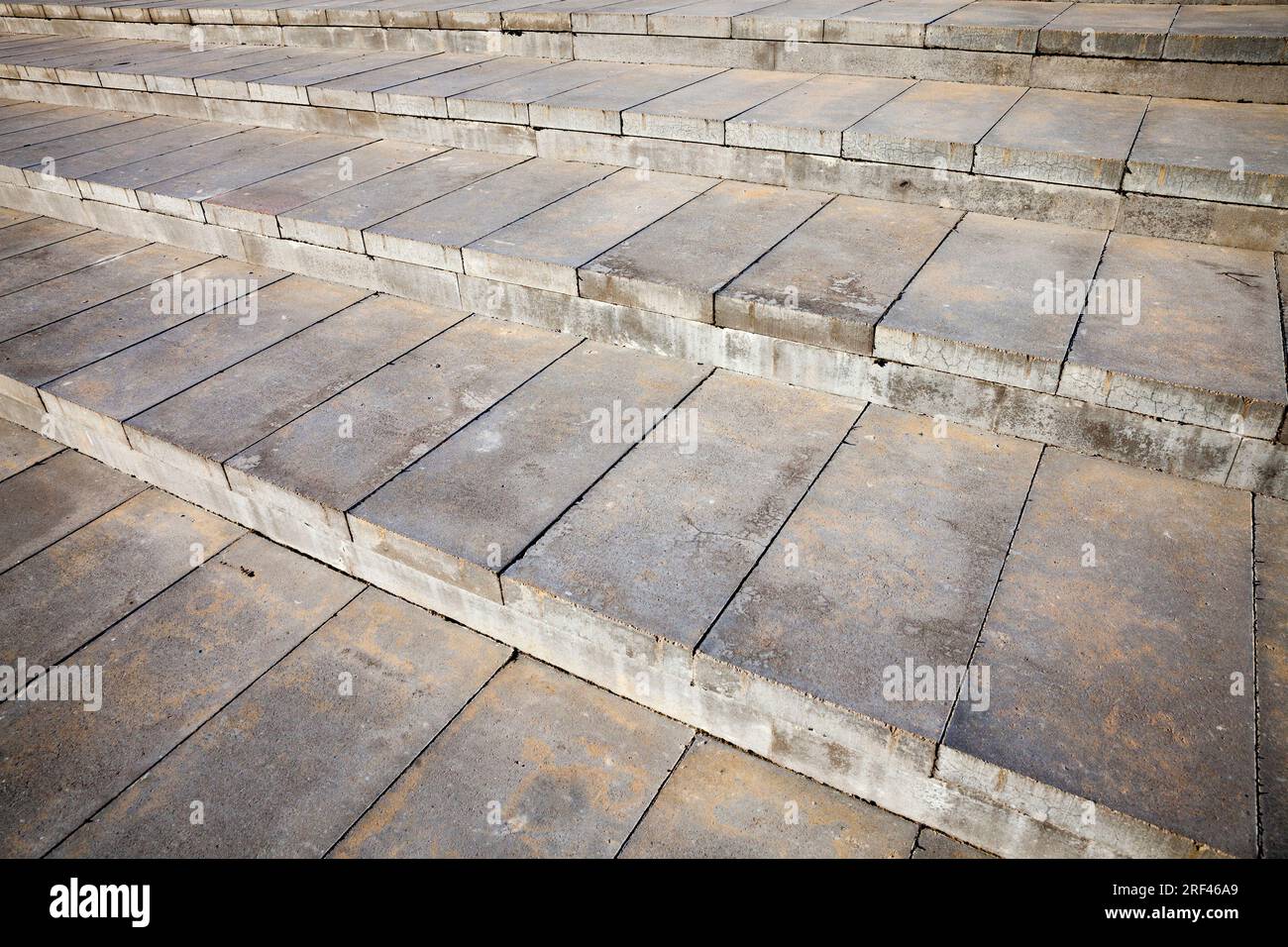 Als Teil einer modernen Treppe mit breiten Stufen besteht die Treppe aus einer großen Anzahl von Betonplatten, nahe eines Teils des Gebäudes Stockfoto