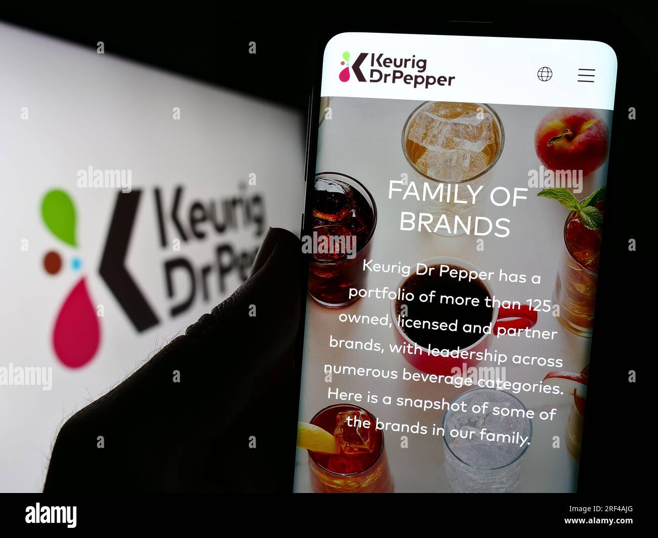 Person, die ein Mobiltelefon mit der Website des US-amerikanischen Getränkeherstellers Keurig Dr. Pepper Inc. Auf dem Bildschirm vor dem Logo hält. Konzentrieren Sie sich auf die Mitte des Telefondisplays. Stockfoto