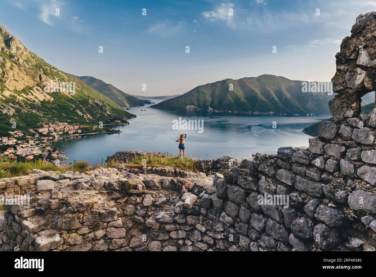 Eine Frau, die zwischen den Ruinen der alten Festung steht Stockfoto