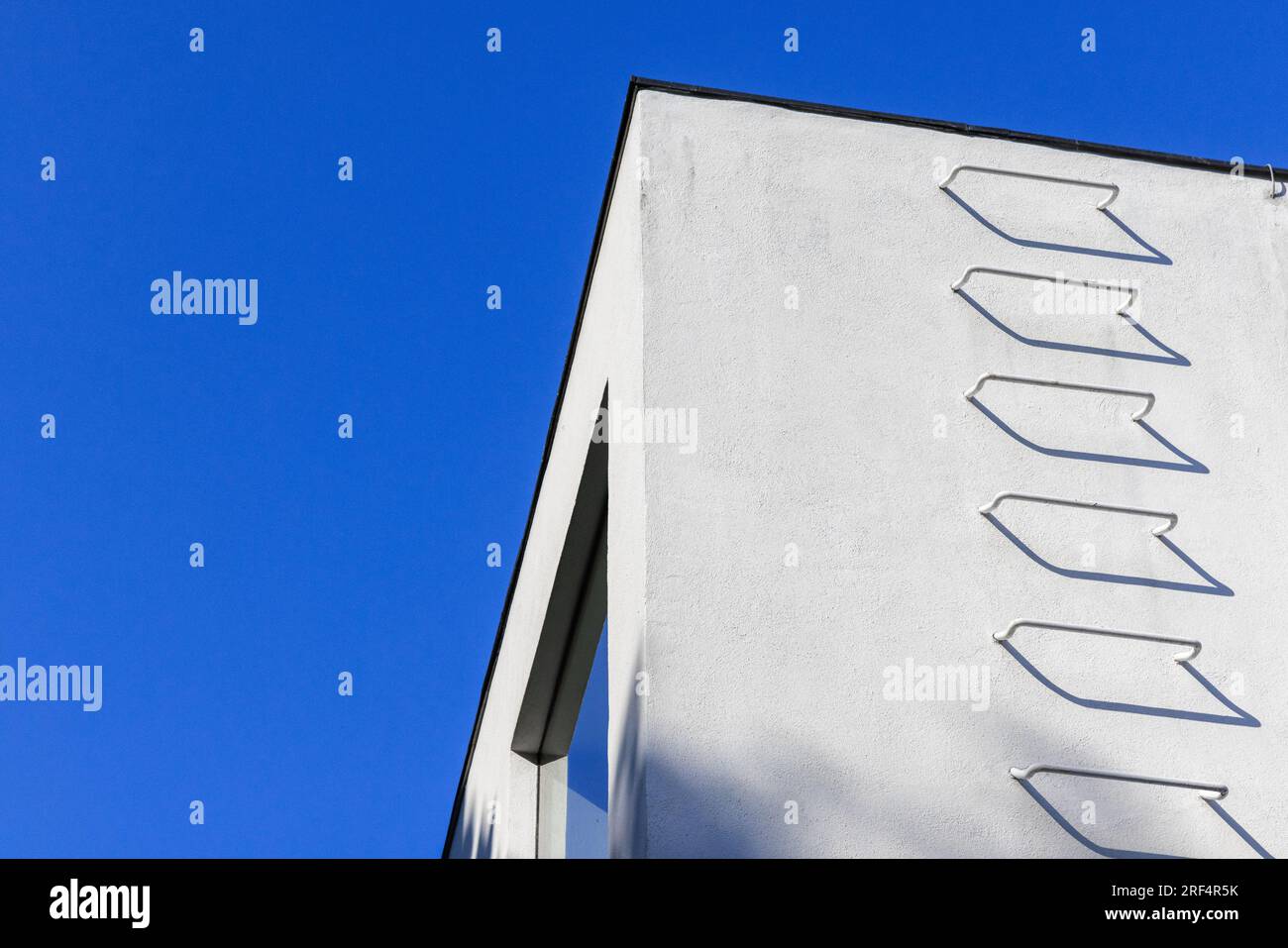 Ecke weißer Wände mit Metalltreppen unter blauem Himmel, Feuertreppe. Abstrakter Architekturhintergrund. Stockfoto
