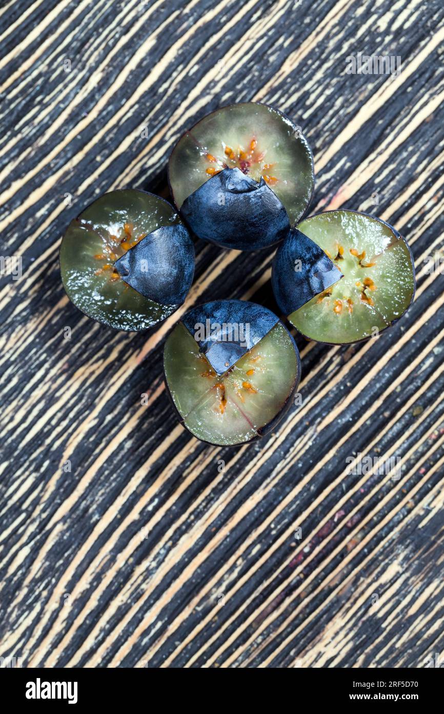 Frisch geerntete und leckere Heidelbeeren in zwei Hälften geschnitten, frisch geschnittene Heidelbeeren, die roh verzehrt werden können, geschnittene Heidelbeeren mit hohem Vitamingehalt Stockfoto