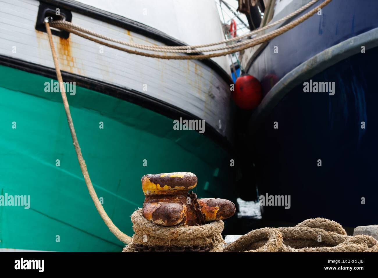 Fischerboote, Die An Rusty Harbor Bollard Gefesselt Sind Stockfoto