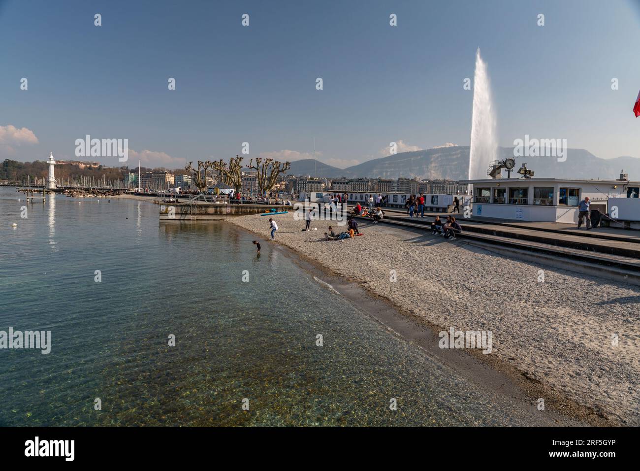Genf, Schweiz - 25. März 2022: Menschen genießen den malerischen Blick auf den Genfer See an der Bucht von Genf, dem französischen Teil der Schweiz. Stockfoto