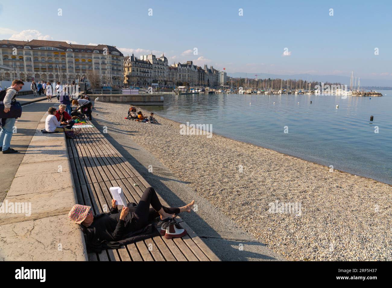 Genf, Schweiz - 25. März 2022: Menschen genießen den malerischen Blick auf den Genfer See an der Bucht von Genf, dem französischen Teil der Schweiz. Stockfoto