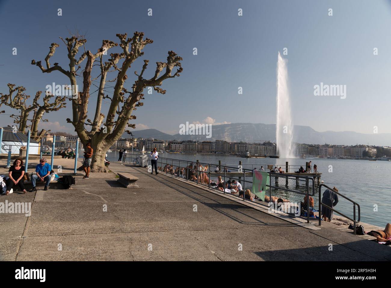 Genf, Schweiz - 25. März 2022: Menschen genießen den malerischen Blick auf den Genfer See an der Bucht von Genf, dem französischen Teil der Schweiz. Stockfoto