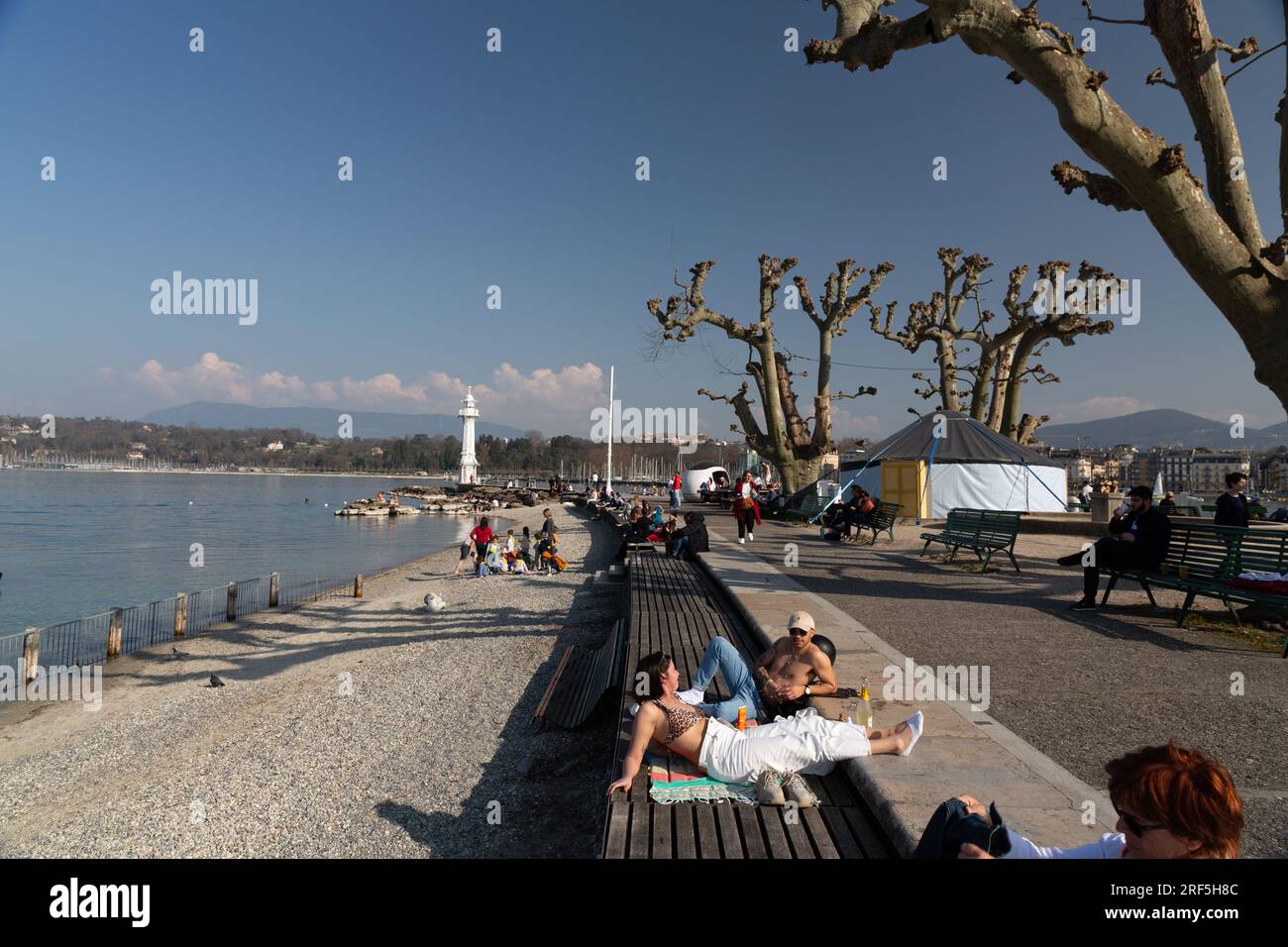 Genf, Schweiz - 25. März 2022: Menschen genießen den malerischen Blick auf den Genfer See an der Bucht von Genf, dem französischen Teil der Schweiz. Stockfoto