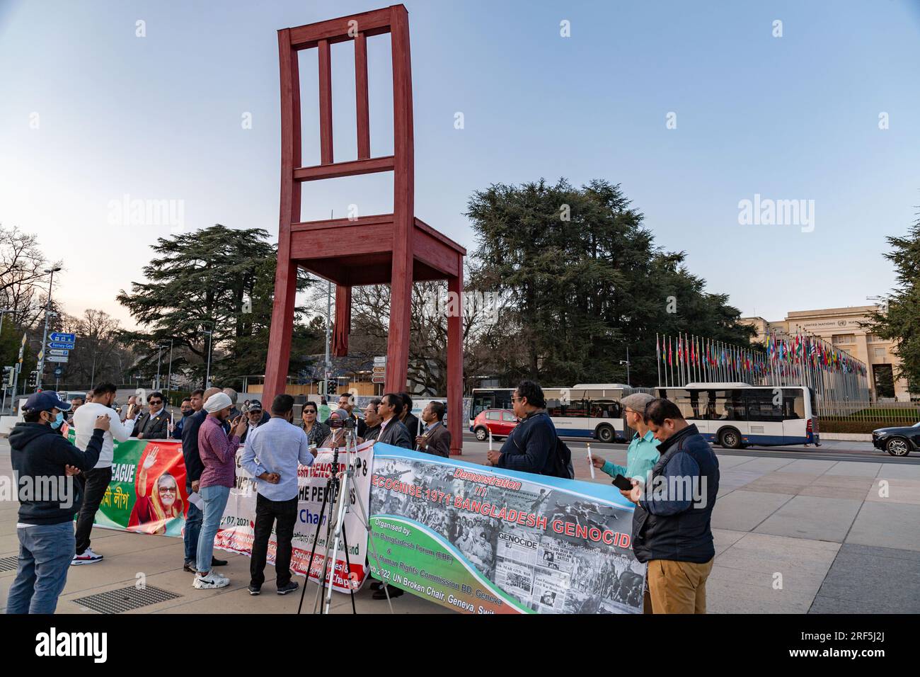 Genf, Schweiz - 25. März 2022: Bangladesch protestiert gegen die monumentale Skulptur des kaputten Stuhls vor dem UN-Büro in Gene Stockfoto