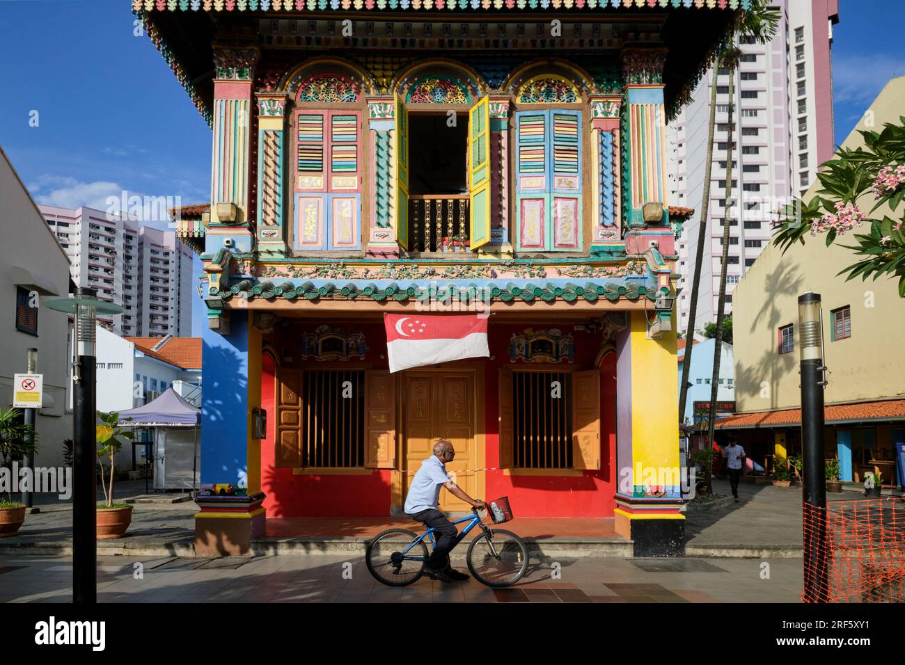 Ein Mann, der am bunten Haus von Tan Teng Niah vorbeiradelt, einer ehemaligen Villa des chinesischen Händlers und heute ein Wahrzeichen in Little India, Singapur Stockfoto