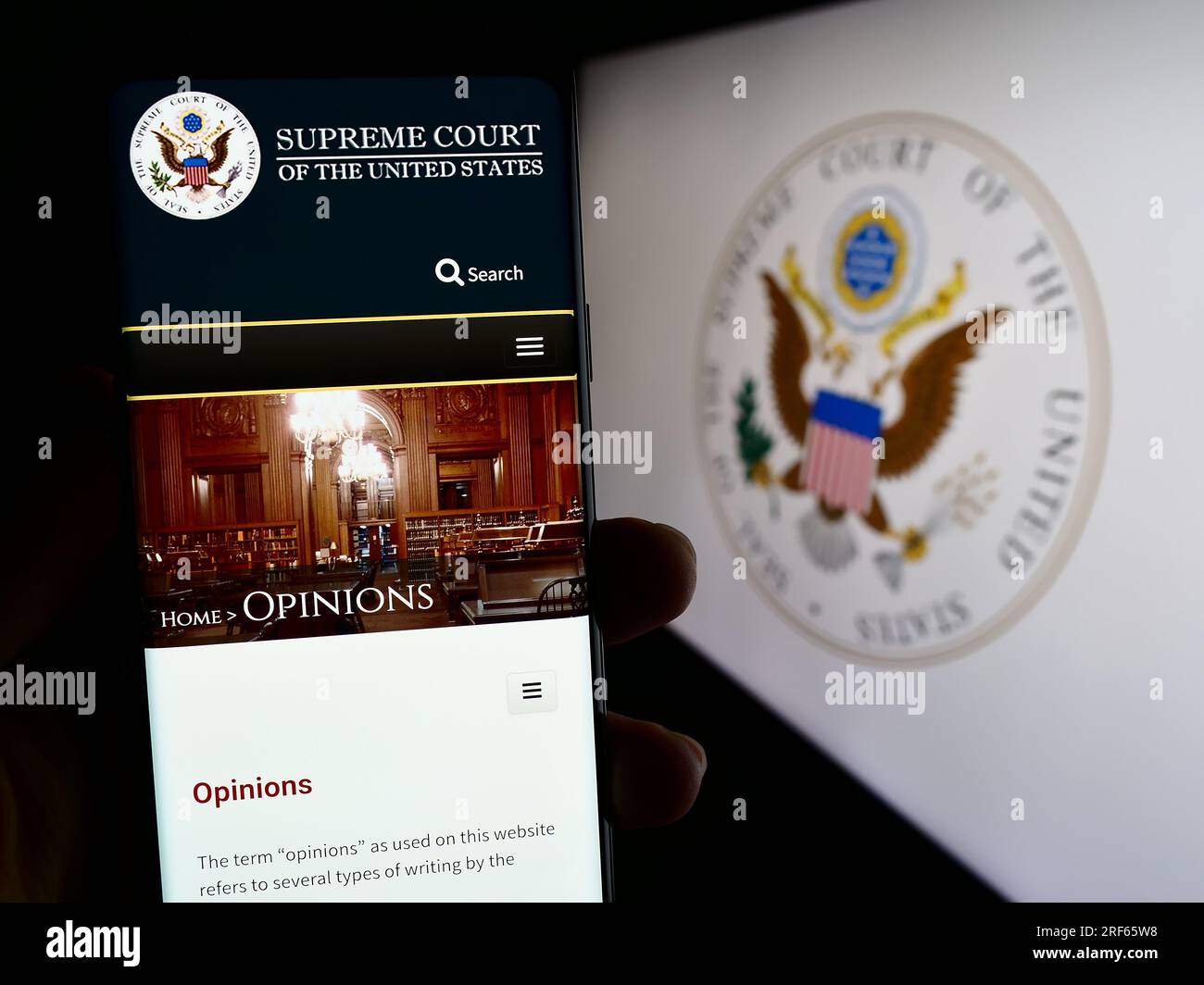 Person, die ein Mobiltelefon mit einer Webseite der USA besitzt Supreme Court (SCOTUS) auf dem Bildschirm vor dem Logo. Konzentrieren Sie sich auf die Mitte des Telefondisplays. Stockfoto