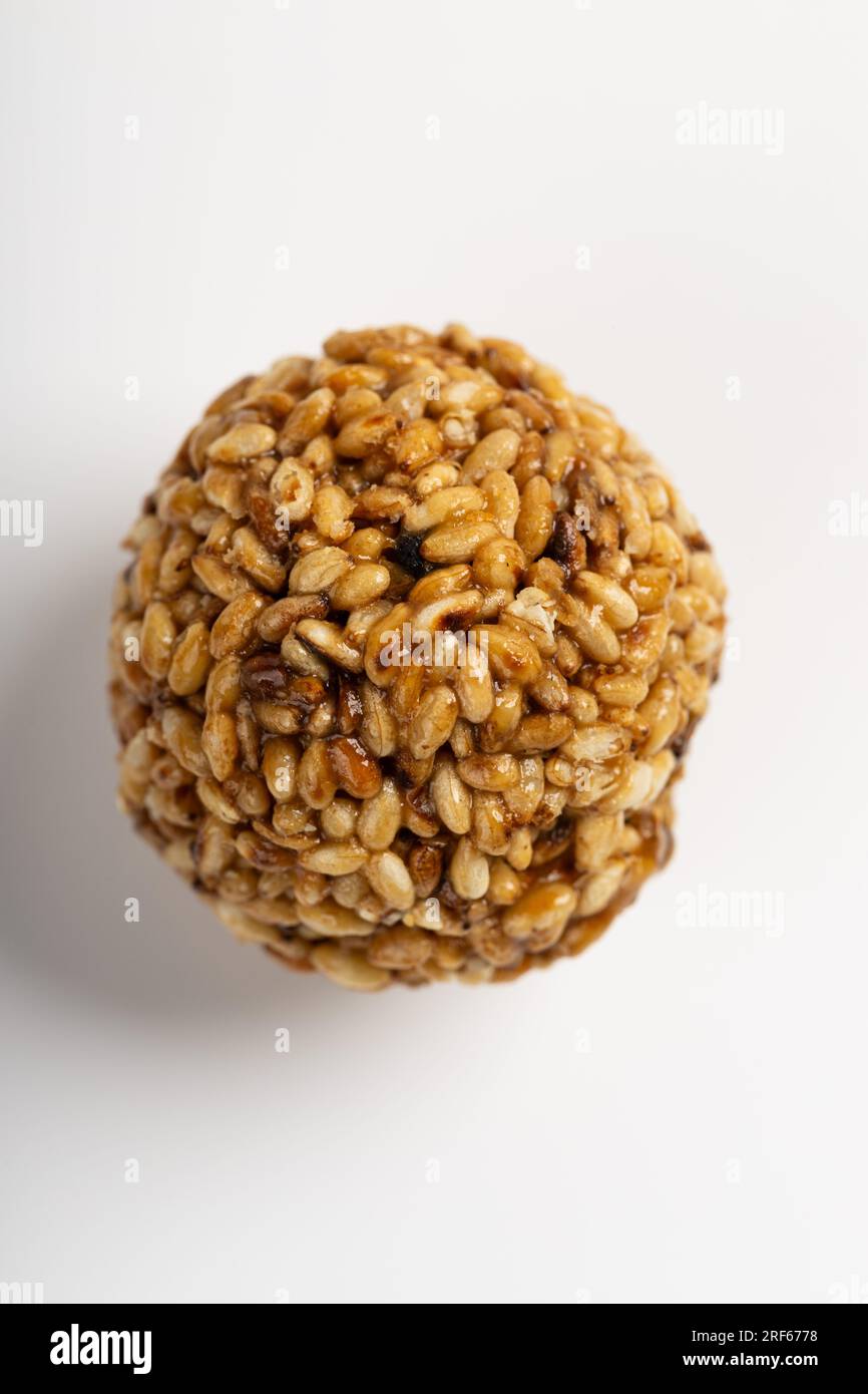 Sesam Ladoo oder Ellunda oder Til ladoo, ein traditionelles indisches süßes Leckerli aus Sesamsamen und Zierkerzen, isoliertes Bild mit weißem Hintergrund. Stockfoto