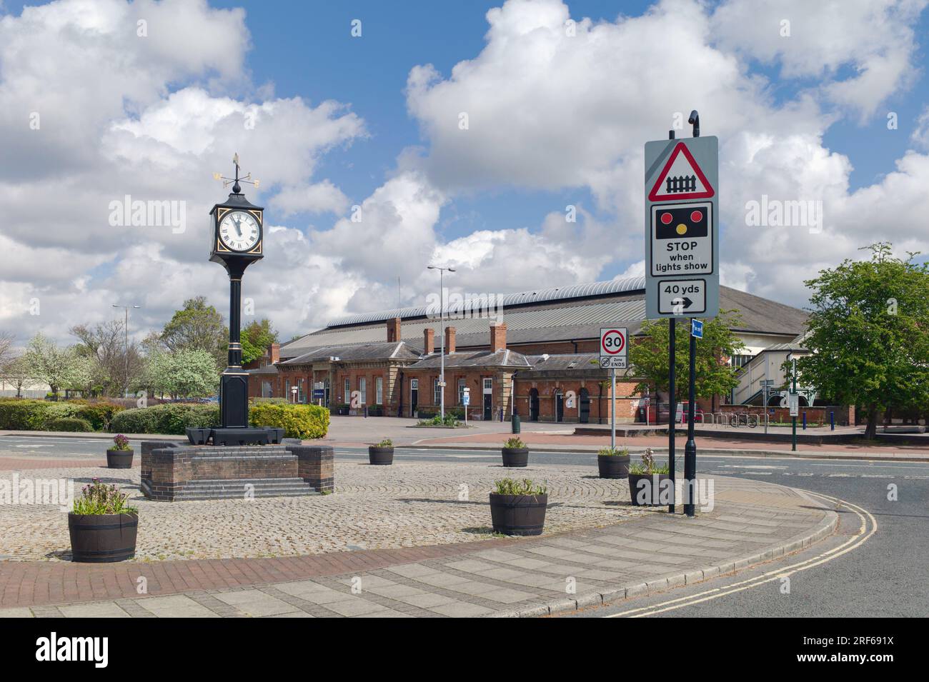 Blick auf den alten Bahnhof und die Uhr auf einem Ziegelsteinsockel an einem schönen Frühlingsmorgen in Beverley, Yorkshire, Großbritannien. Stockfoto