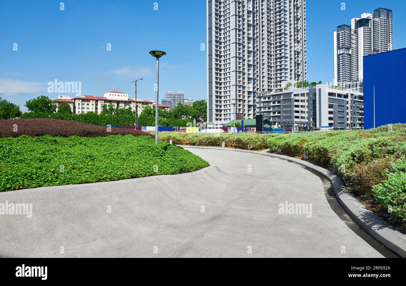 Geschwungener Betonweg in einem modernen Stadtgarten Stockfoto