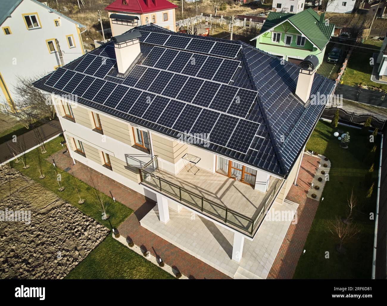 Wohnsitz mit Solarpaneelsystem zur Stromerzeugung durch Photovoltaik. Luftaufnahme des zweistöckigen Hauses mit Solarmodulen auf dem Dach. Konzept ökologischer erneuerbarer Energiequellen. Stockfoto