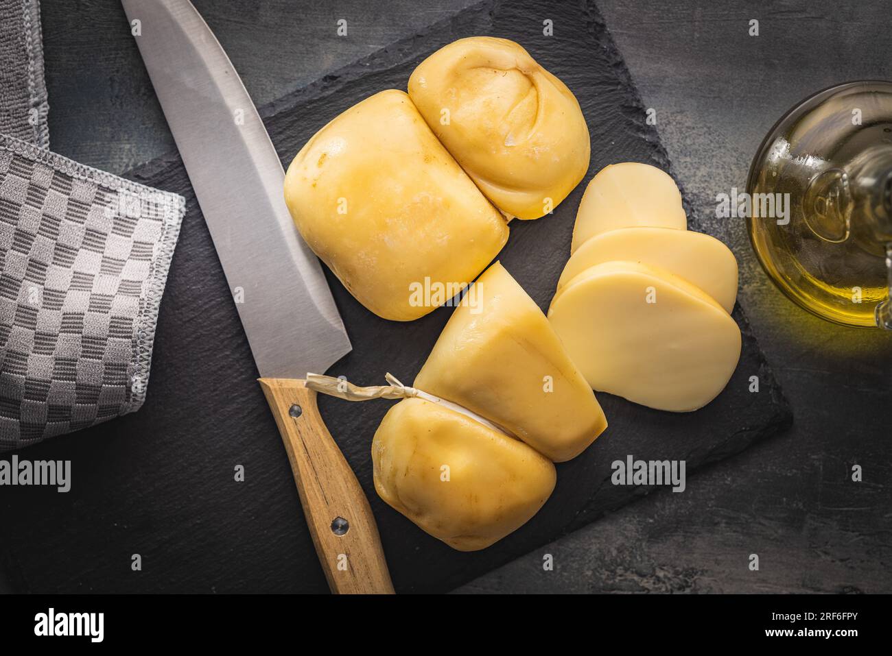 Geräucherter Scamorza-Käse auf dem Schneidebrett. Draufsicht. Stockfoto