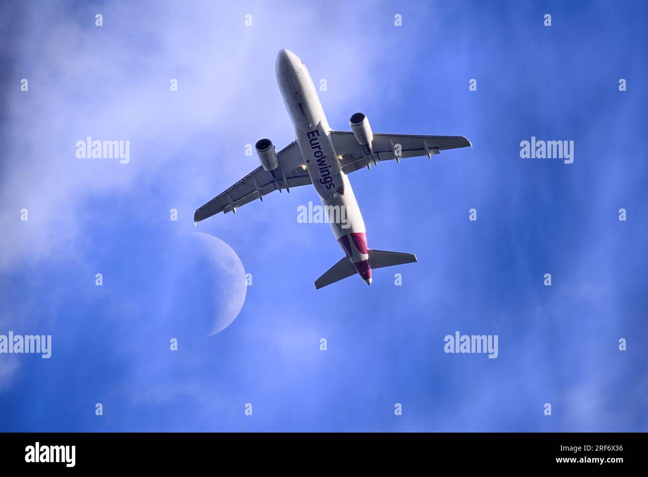 Passagierflugzeug der Fluggesellschaft Eurowings bei einem Rendezvous mit dem Mond über Hamburg, Deutschland Stockfoto
