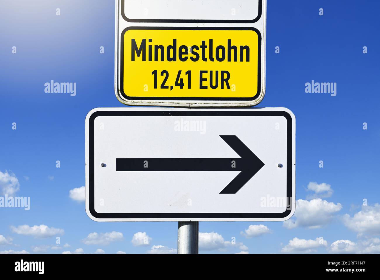 FOTOMONTAGE, Schild mit Pfeil und Aufschrift Mindestlohn 12,41 Euro Stockfoto