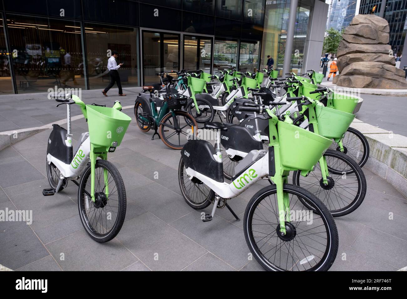 Am 6. Juli 2023 in London, Vereinigtes Königreich, auf der anderen Straßenseite geparkte Limettenelektrofahrräder. Ein Fahrrad-Sharing-System oder ein Fahrrad-Sharing-Programm ist ein gemeinsamer Transportservice, bei dem Fahrräder für die gemeinsame Nutzung durch Einzelpersonen gegen eine Gebühr zur Verfügung stehen. Die Programme selbst umfassen sowohl Docking- als auch docklose Systeme. Stockfoto