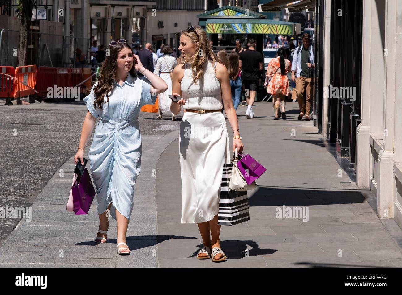 Zwei Käufer in der Bond Street mit ihren Liberty-Taschen am 7. Juli 2023 in London, Großbritannien, im exklusiven Bereich von Mayfair. Traditionell wohlhabende Teile von West London haben sich zu wohlhabenden Spielplätzen der Superreichen entwickelt, mit Zuströmen von ausländischem Geld, insbesondere aus dem Nahen Osten, Russland und China. Jüngsten Untersuchungen zufolge sind in der britischen Hauptstadt mehr Menschen mit hohem Nettowert und ultrahohem Nettowert als in jeder anderen Stadt der Welt zu Hause. Stockfoto