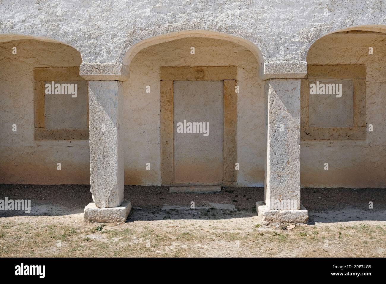 Bögen mit einer abgeschlossenen Eingangstür und Fenstern in einem verlassenen Gebäude in Portugal Stockfoto