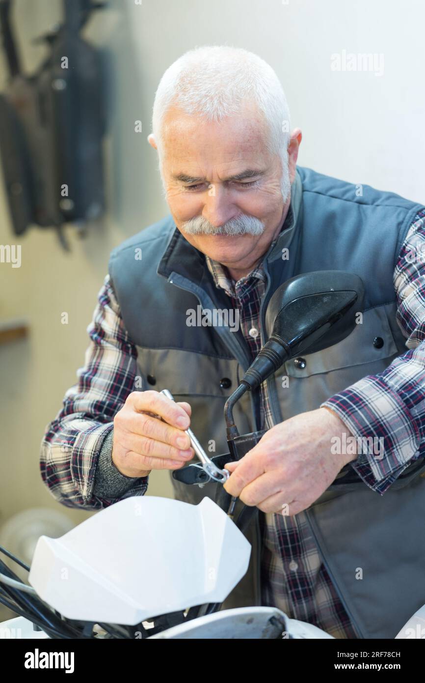 Leitender Mechaniker mit Schraubenschlüssel am Lenker Stockfoto