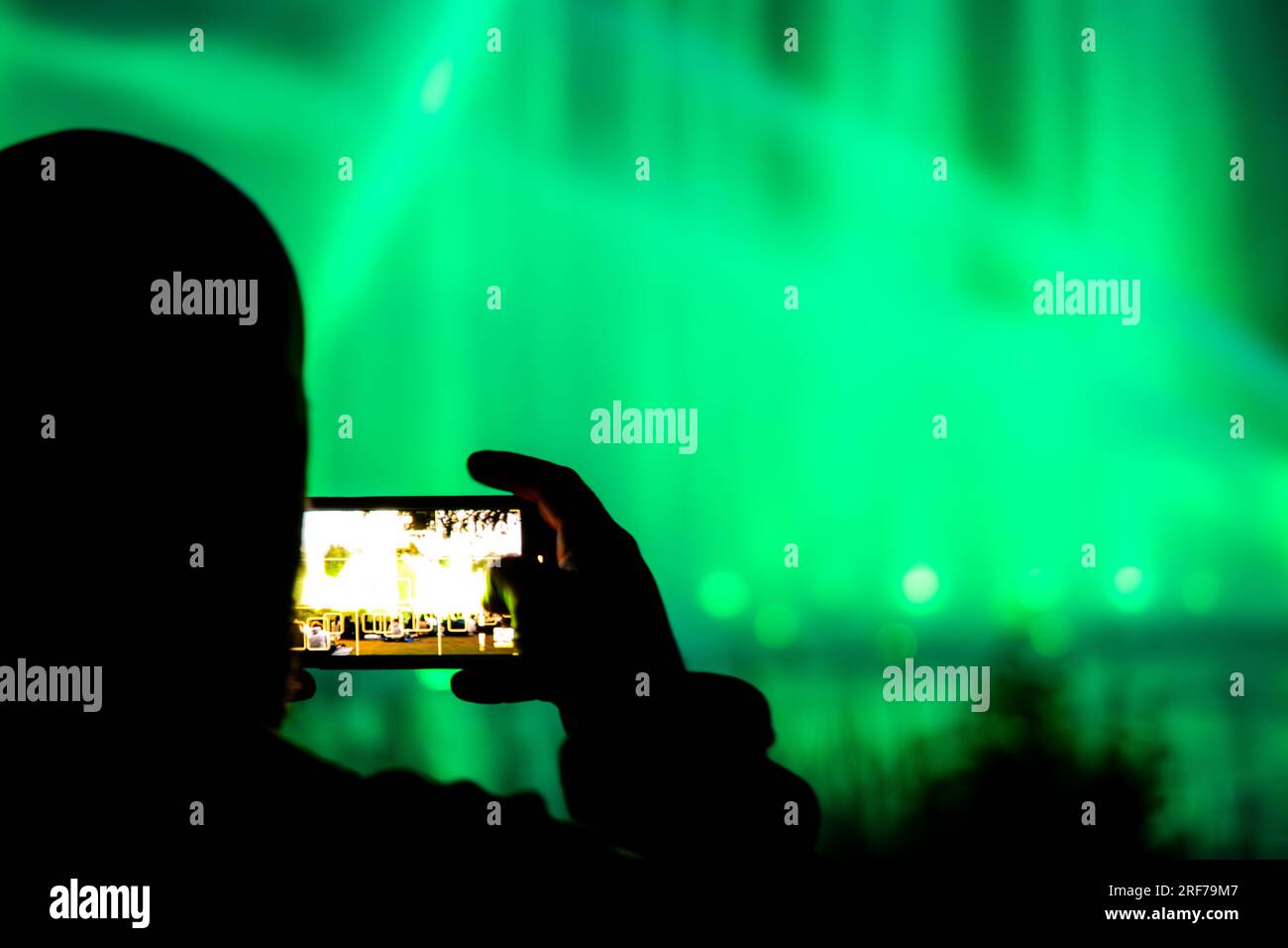 Ein Mann, der die Lichtshow im Park Planten un Blomen in Hamburg aufnimmt Stockfoto