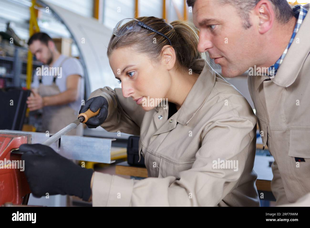 Mechanikerin und Mann, der in der Nähe eines Flugzeugs im Hangar arbeitet Stockfoto