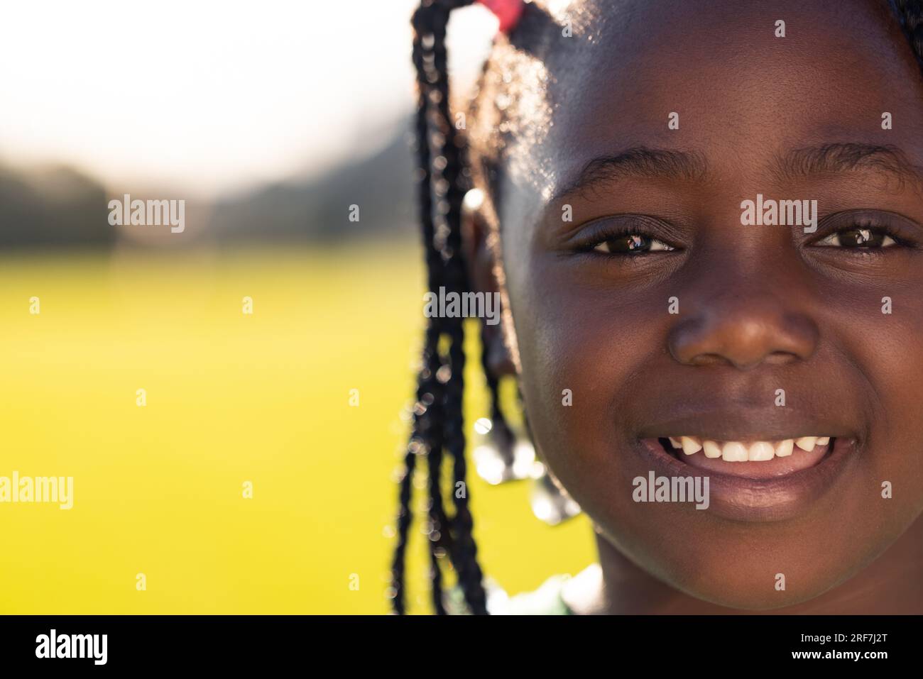 Portrait einer glücklichen afroamerikanischen Schulmädchen auf dem Sportplatz der Grundschule, Kopierraum Stockfoto