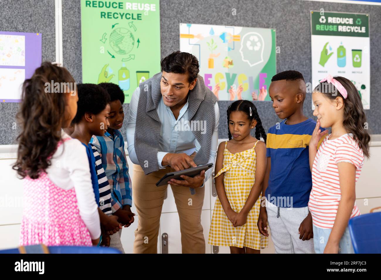 Birassischer männlicher Lehrer mit Tablet-Unterricht in der Grundschule Stockfoto