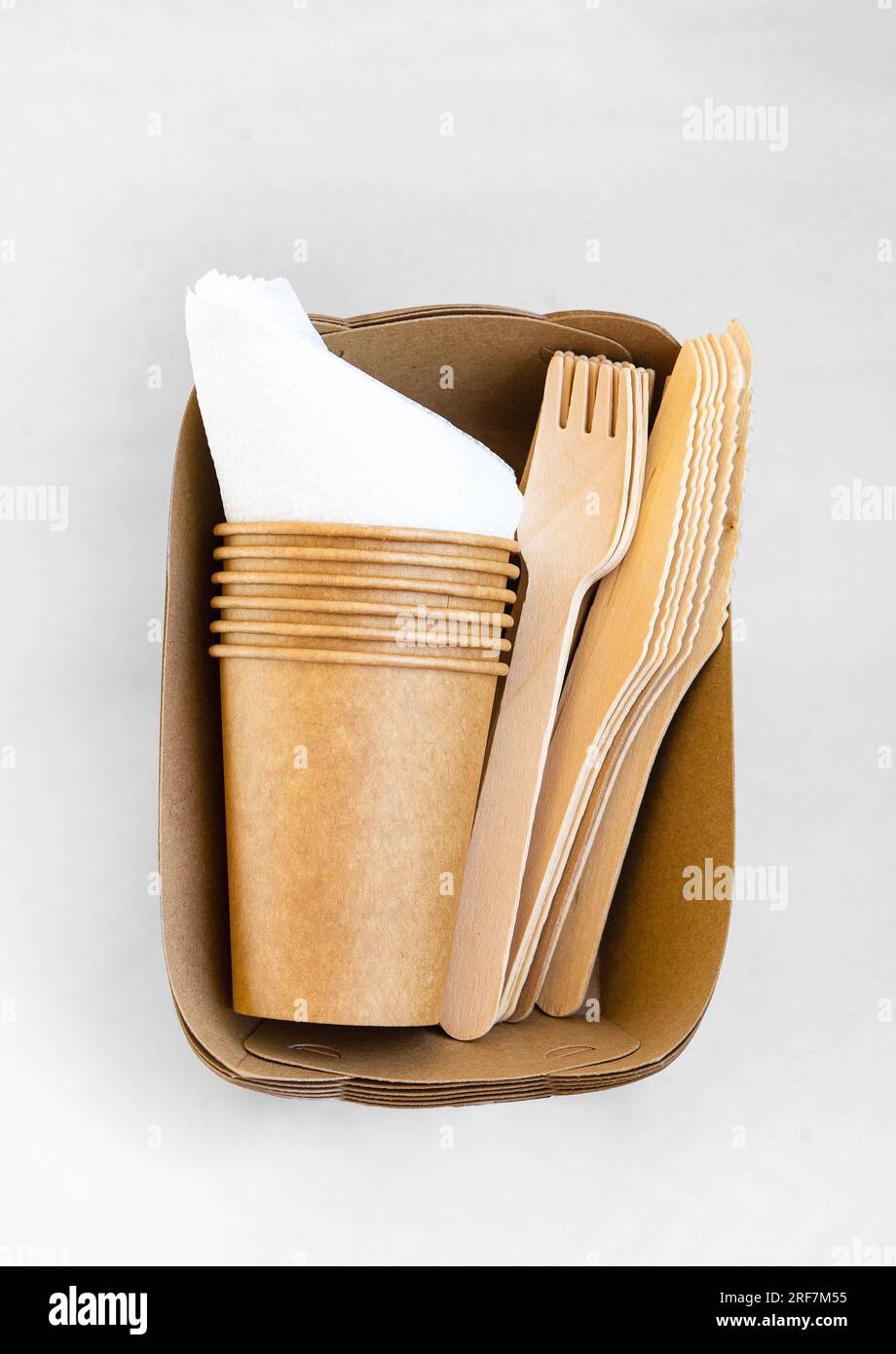 Umweltfreundliche Einwegverpackungen für Lebensmittel. Braune Papierbehälter, Getränkegläser, Gabeln und Messer. Modell, Vorlage. Stockfoto