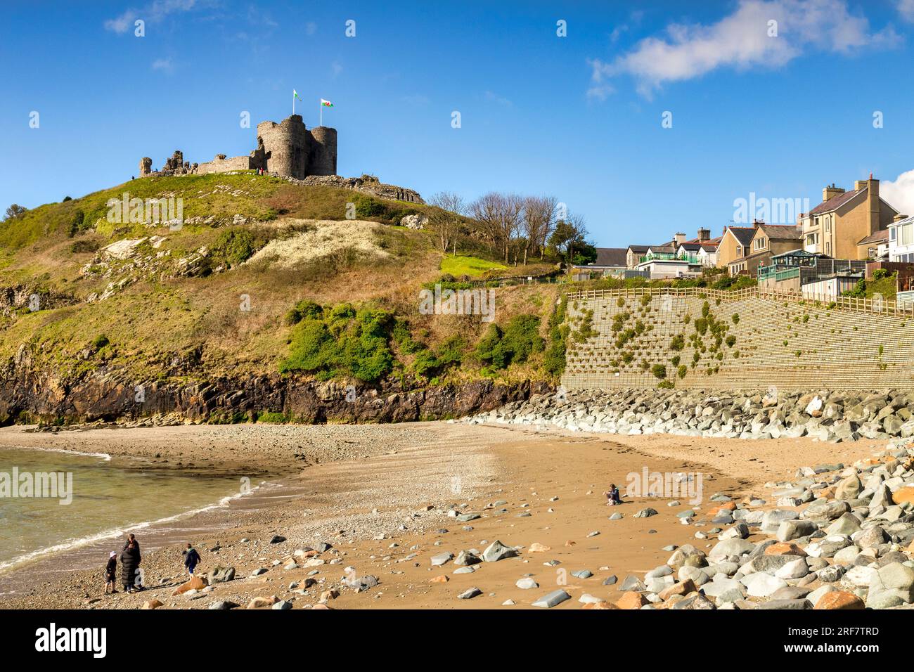 15. April 2023: Criccieth, Wales, Vereinigtes Königreich - Criccieth Castle und Strand, entfernte Familie am Strand. Stockfoto