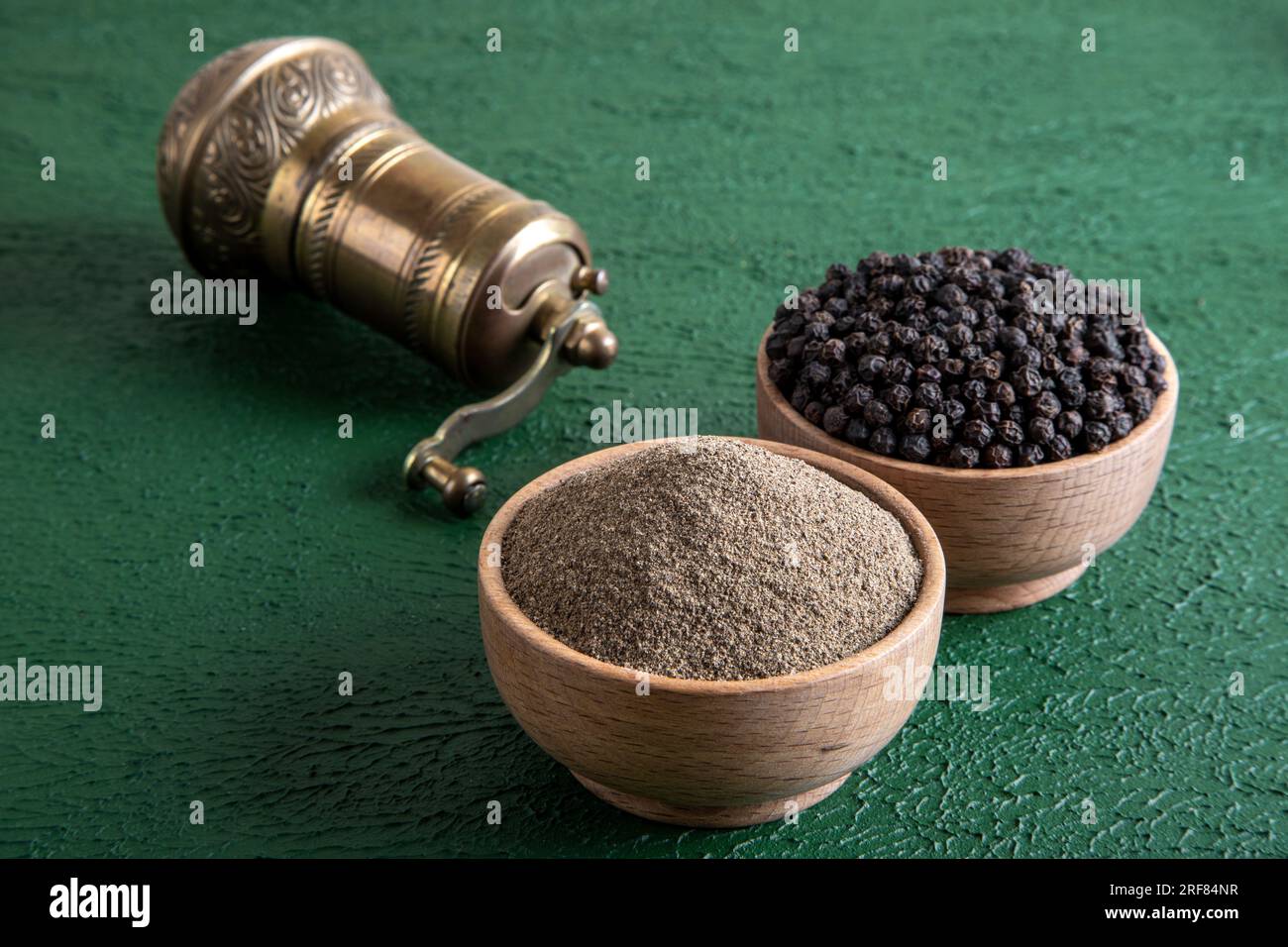 Schwarze Pfefferkörner, gemahlener schwarzer Pfeffer und Metallmühle, Draufsicht Stockfoto