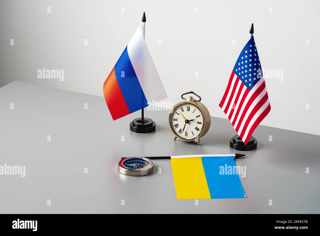 Flaggen der USA, Russlands und der Ukraine auf grauem Hintergrund Stockfoto