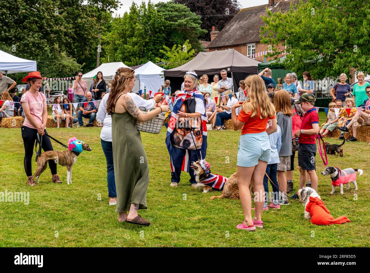 Eine Rosette wird dem Gewinnerhund und Besitzer bei der Fairwarp Fete Dog Show, Fairwarp, East Sussex, Großbritannien, gegeben Stockfoto