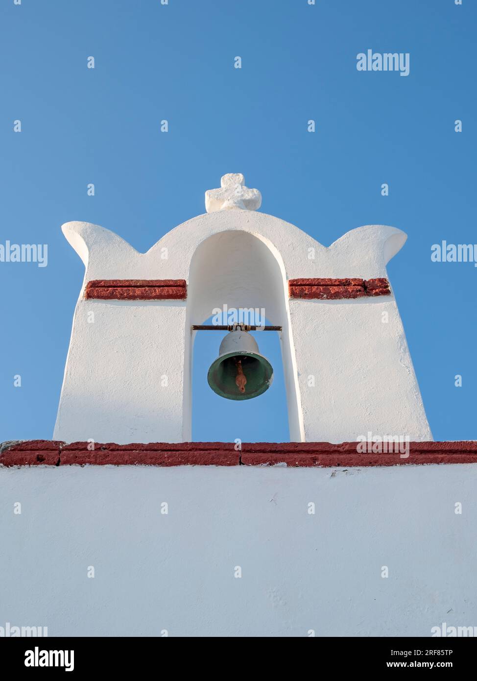 Niedriger Winkel mit weißgetünchtem Glockenturm und blauem Himmel im Hintergrund, Ia (Oia), Santorin, Griechenland Stockfoto