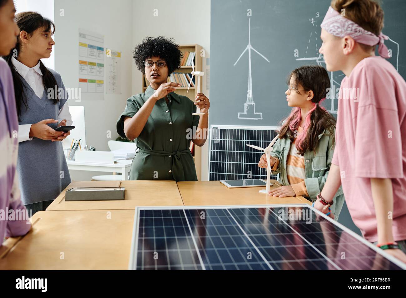 Afroamerikanischer Lehrer, der den Schülern während des Unterrichts die Arbeit der Windmühle erklärt Stockfoto