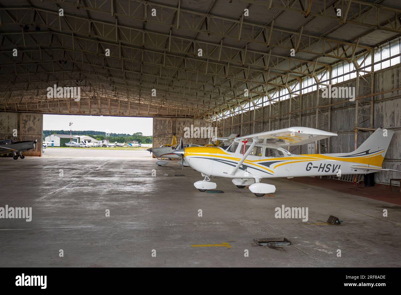 Leichte Flugzeuge parkten in einem Hangar an einem kleinen Flughafen. Stockfoto