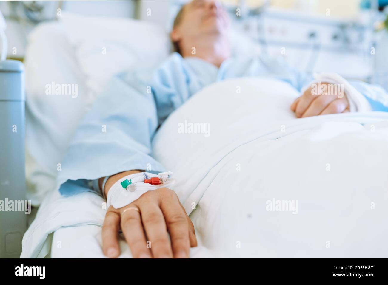 Männlicher Patient nach Verletzung oder Operation auf der Krankenhausstation Stockfoto