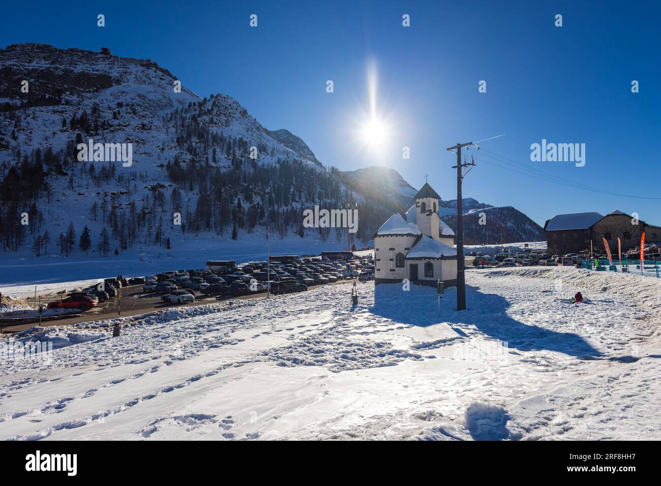 Falcade, Italien - 14. Februar 2023: Kirche im Bergdorf Falcade, Gemeindekirche im Tal, Winterszene mit schneebedeckten Dächern. Eingebettete BU Stockfoto