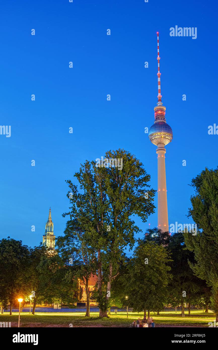 Der berühmte Fernsehturm mit dem Turm der Marienkirche in Berlin bei Nacht Stockfoto