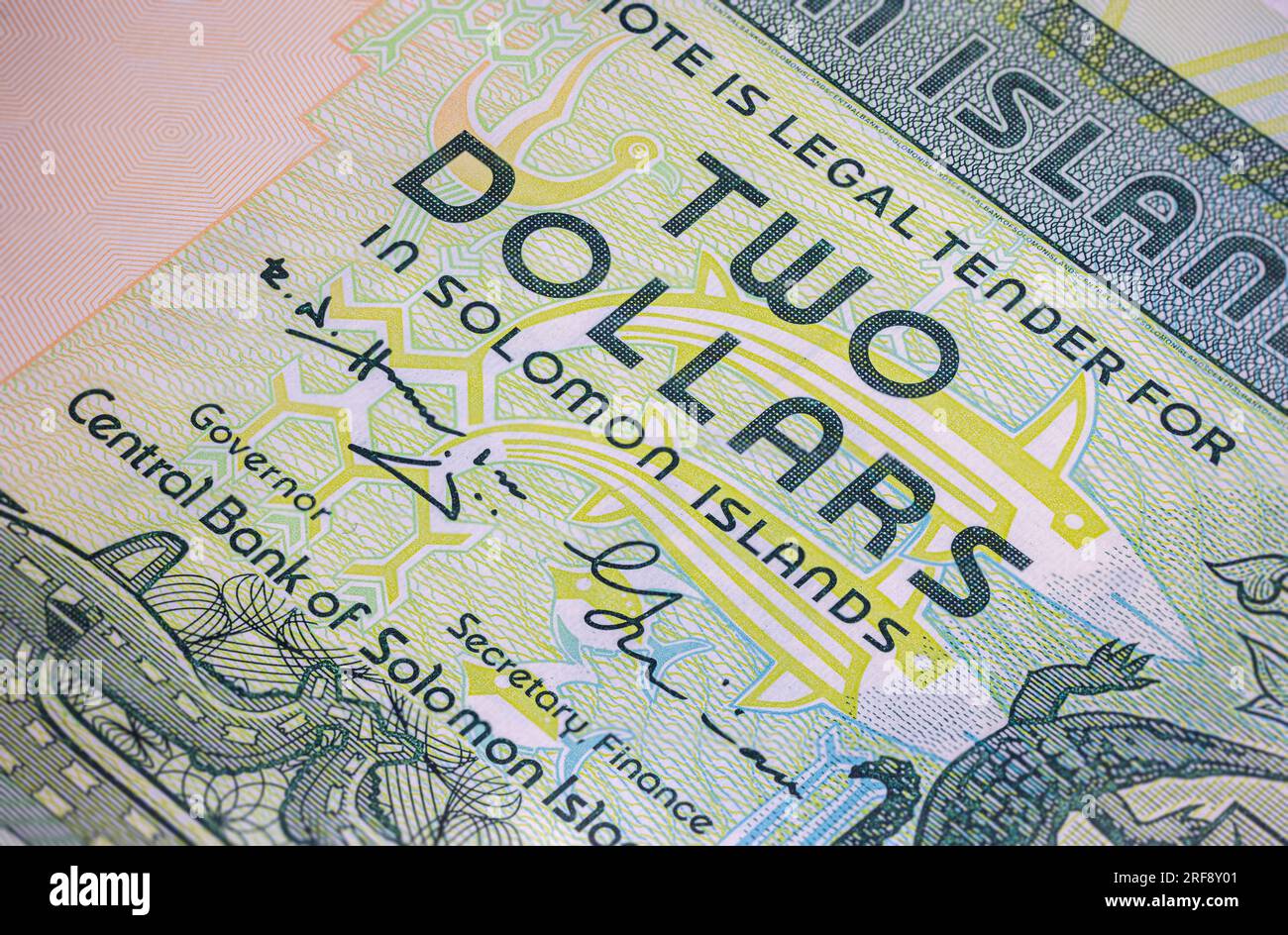 Der 2-Dollar-Schein der Salomonen ist mit komplexen Kunstwerken und Design verziert. Eine Nahaufnahme zeigt lebendige Farben, einheimische Motive und ein Porträt Stockfoto