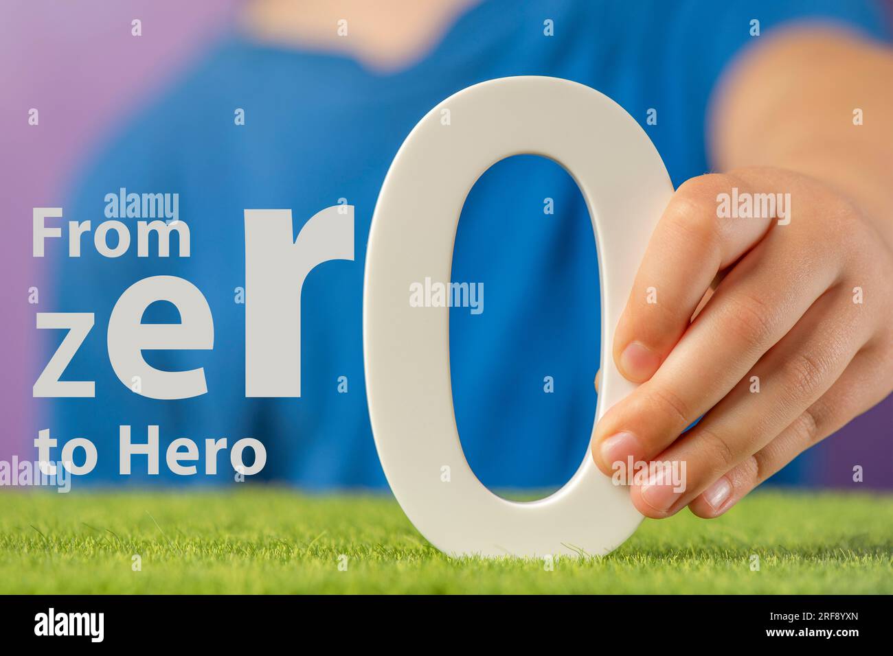 Von Null zu Hero. Nahaufnahme eines Konzeptfotos einer Hand mit einer weißen Null. Motivierender Text, der zu neuen Erfolgen und dem Streben nach Erfolg inspiriert. Stockfoto