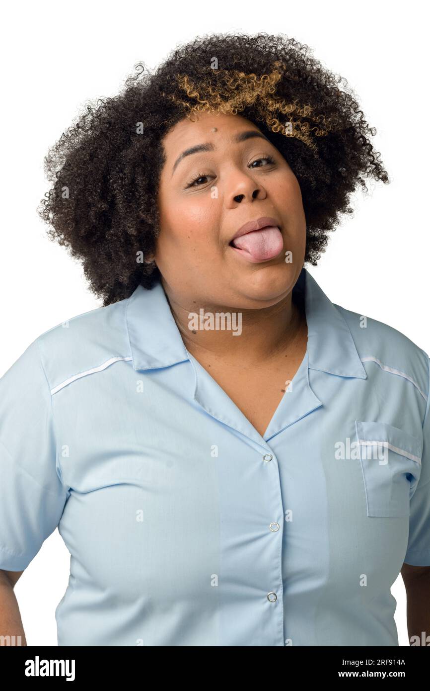 Taille hoch vertikales Porträt einer glücklichen jungen afro-lateinischen Ärztin in blauer Uniform, die in die Kamera schaut, vor weißem Hintergrund. Stockfoto