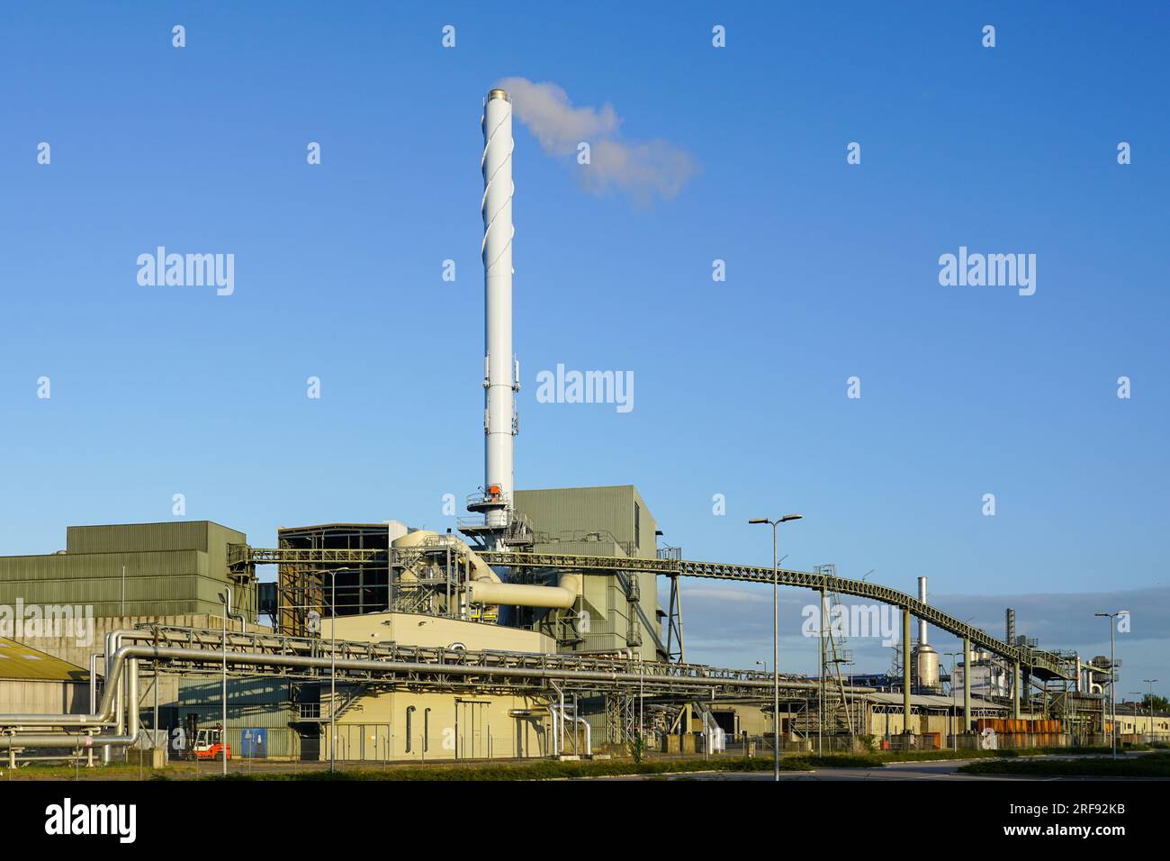 Außenansicht der Ausrüstung eines großen modernen Biomasse-Kraft-Wärme-Kopplungs-Kraftwerks, Holzspäne-Kraftwerks, blauer Himmel-Hintergrund Stockfoto